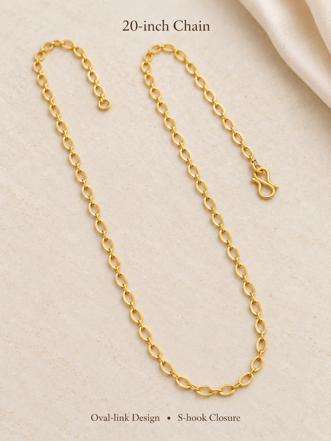 20 inch gold plated oval link chain with S-hook closure on cream fabric