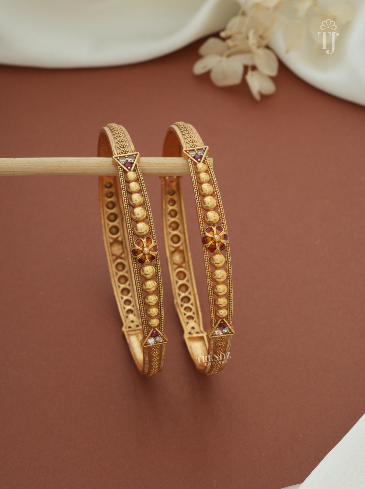 Antique finish beaded artificial bangles for women, gold plated brass, pair — front view