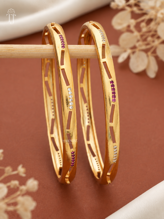 Glossy pink white stone cutout artificial bangles on stick stand, warm backdrop
