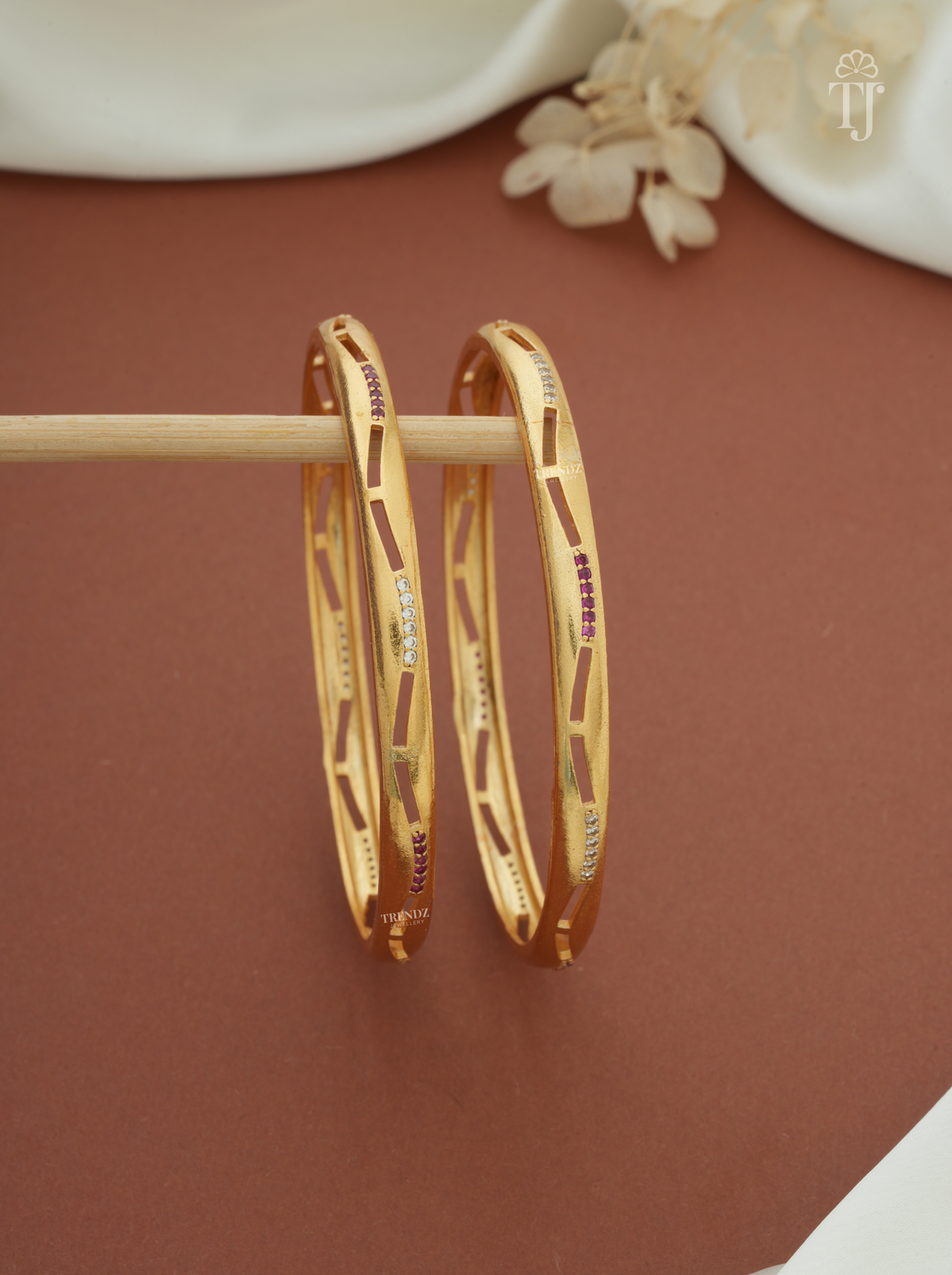 Pink white stone cutout artificial bangles for women, gold plated brass, pair — front view