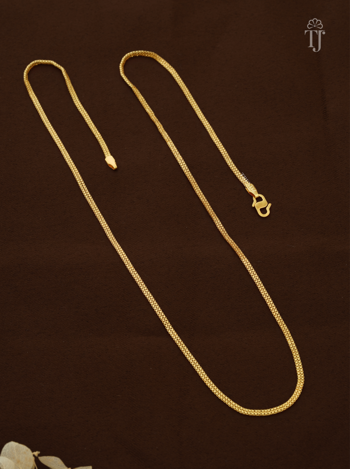 Artificial chain for girls with thin gold plated box links and S-hook on brown fabric