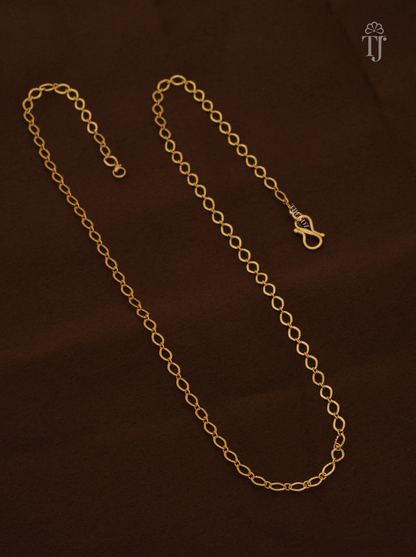 Artificial gold chain for ladies with oval links and S-hook on brown fabric