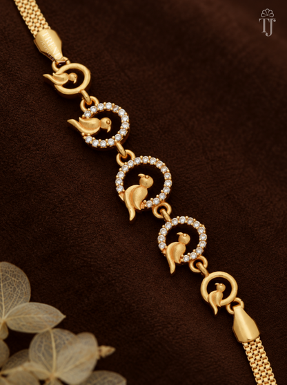 Close-up of gold bird charms inside white AD stone rings on brown velvet