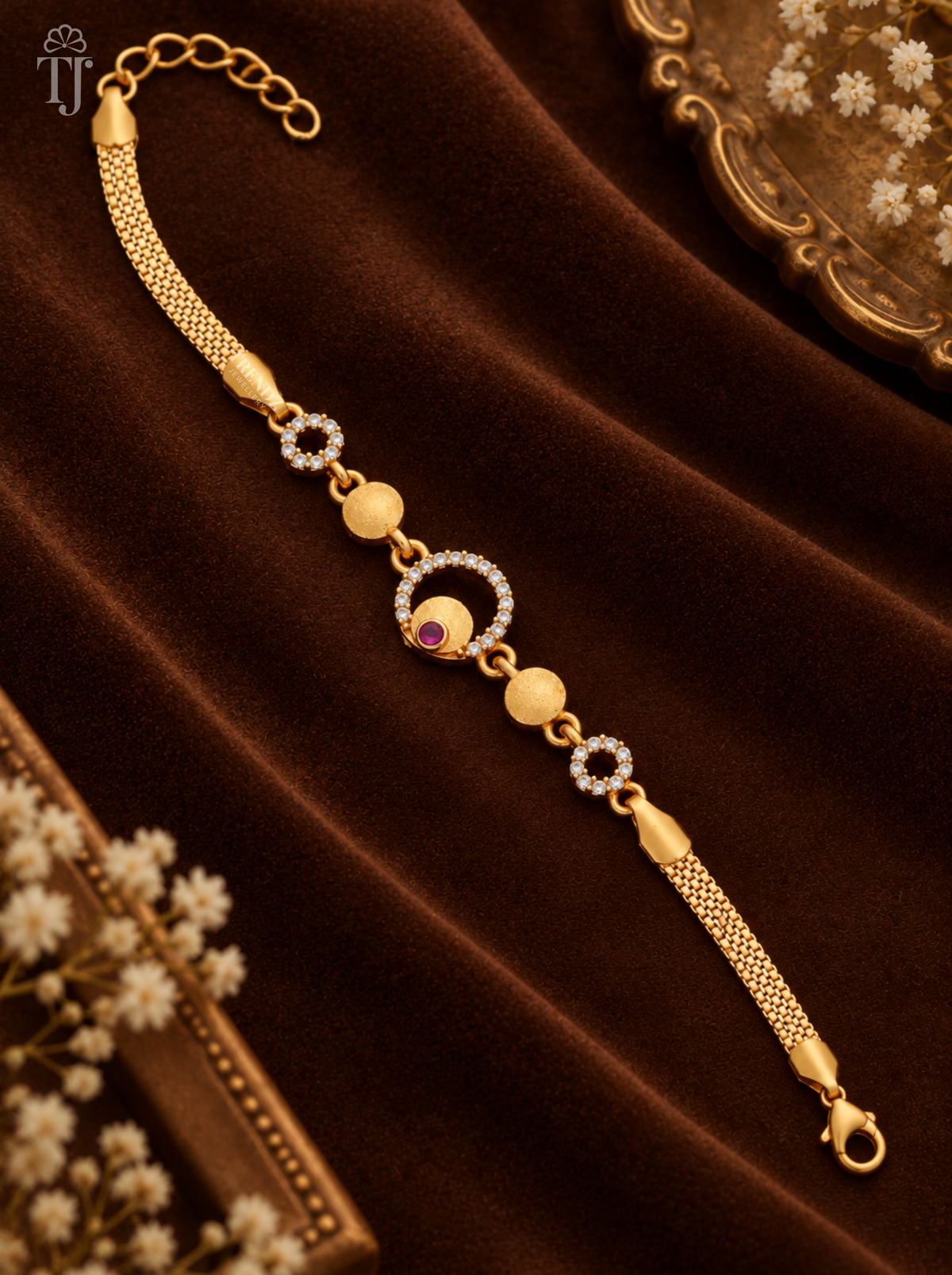 Bracelet design for girl, gold plated with pink stone round charm, mesh chain and lobster clasp on brown velvet