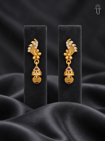 Gold plated feather design jhumka earrings with AD stones on black display stand