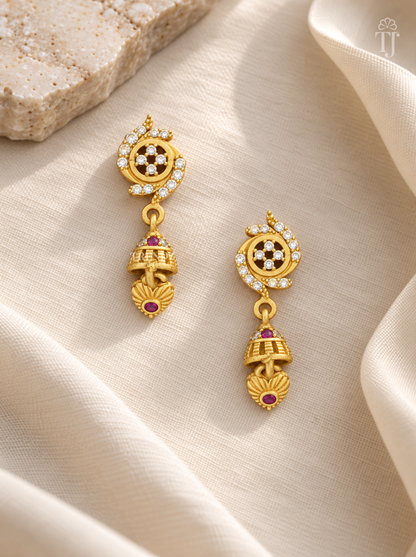 Pair of gold plated AD stone flower earrings with pink stone jhumka on cream linen