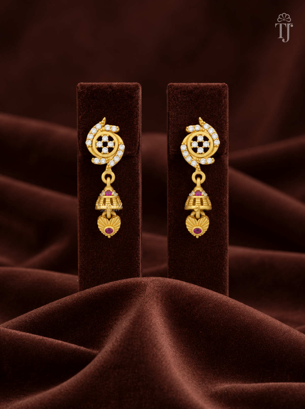 Gold plated stone flower jhumka earrings on brown velvet display stand