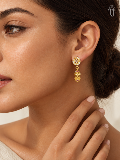 Woman wearing small gold plated stone flower jhumka earrings