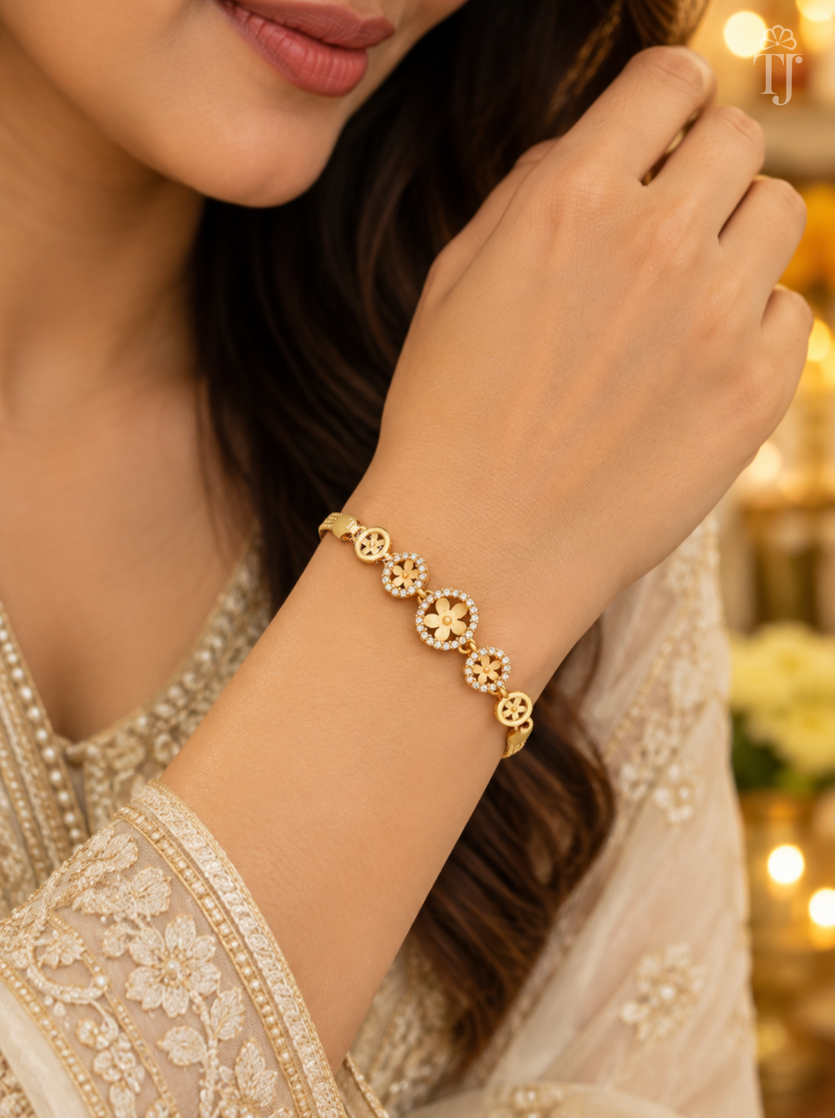 Woman in cream embroidered kurta wearing gold plated flower bracelet on her wrist