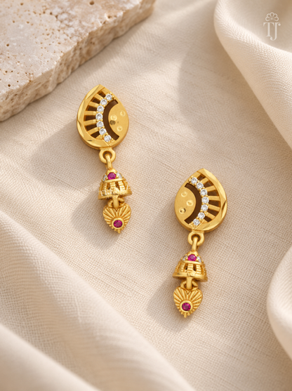 Pair of gold plated half moon earrings with pink stone jhumka on cream linen
