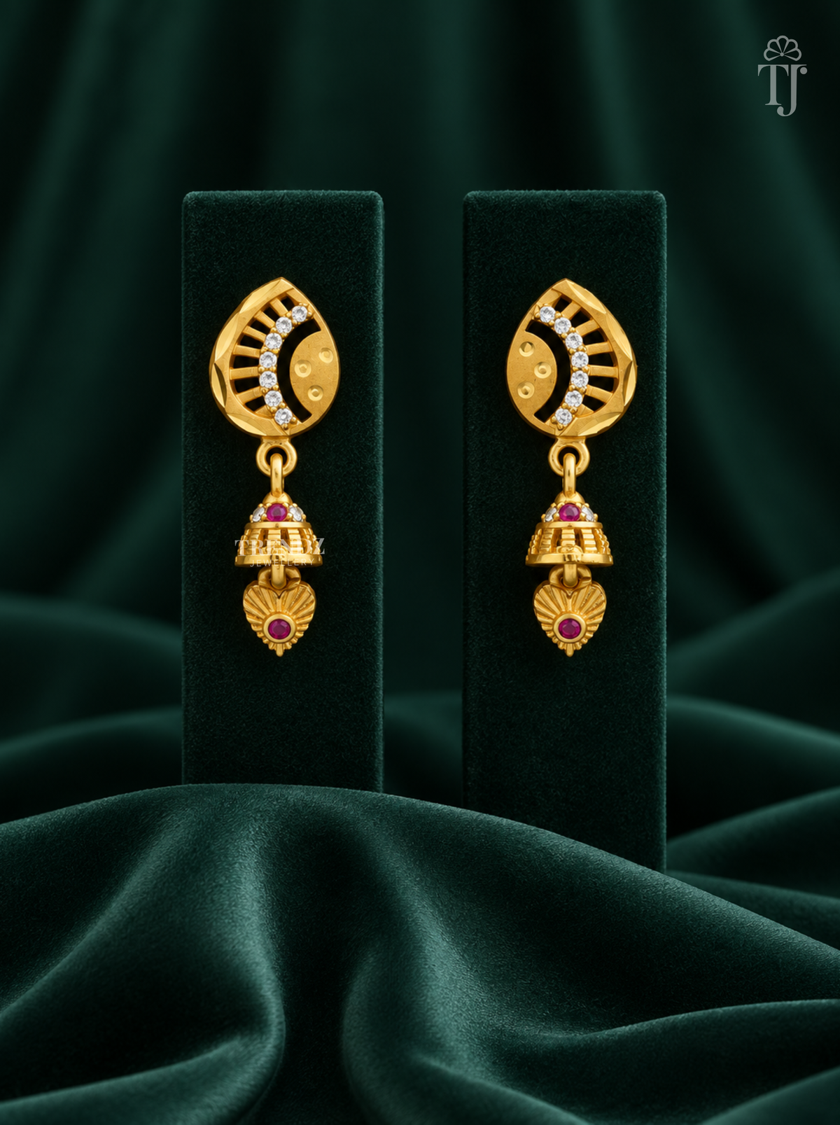 Gold plated half moon jhumka earrings with AD stones on dark green velvet display stand
