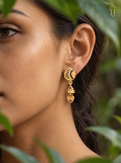 Side view of woman wearing gold plated half moon jhumka drop earrings