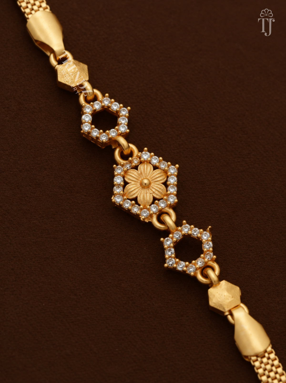 Close-up of hexagon charm with six-petal gold flower and white AD stone border