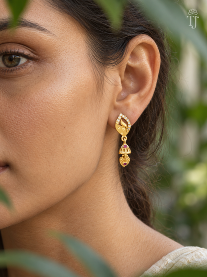 Side view of woman wearing gold plated leaf design jhumka drop earrings