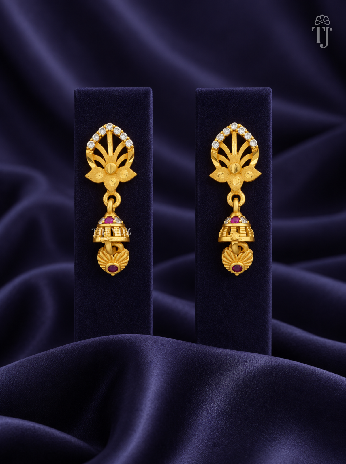 Gold plated lotus jhumka earrings with AD stones on navy velvet display stand