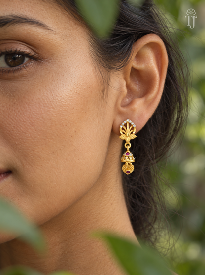 Side view of woman wearing gold plated lotus jhumka drop earrings
