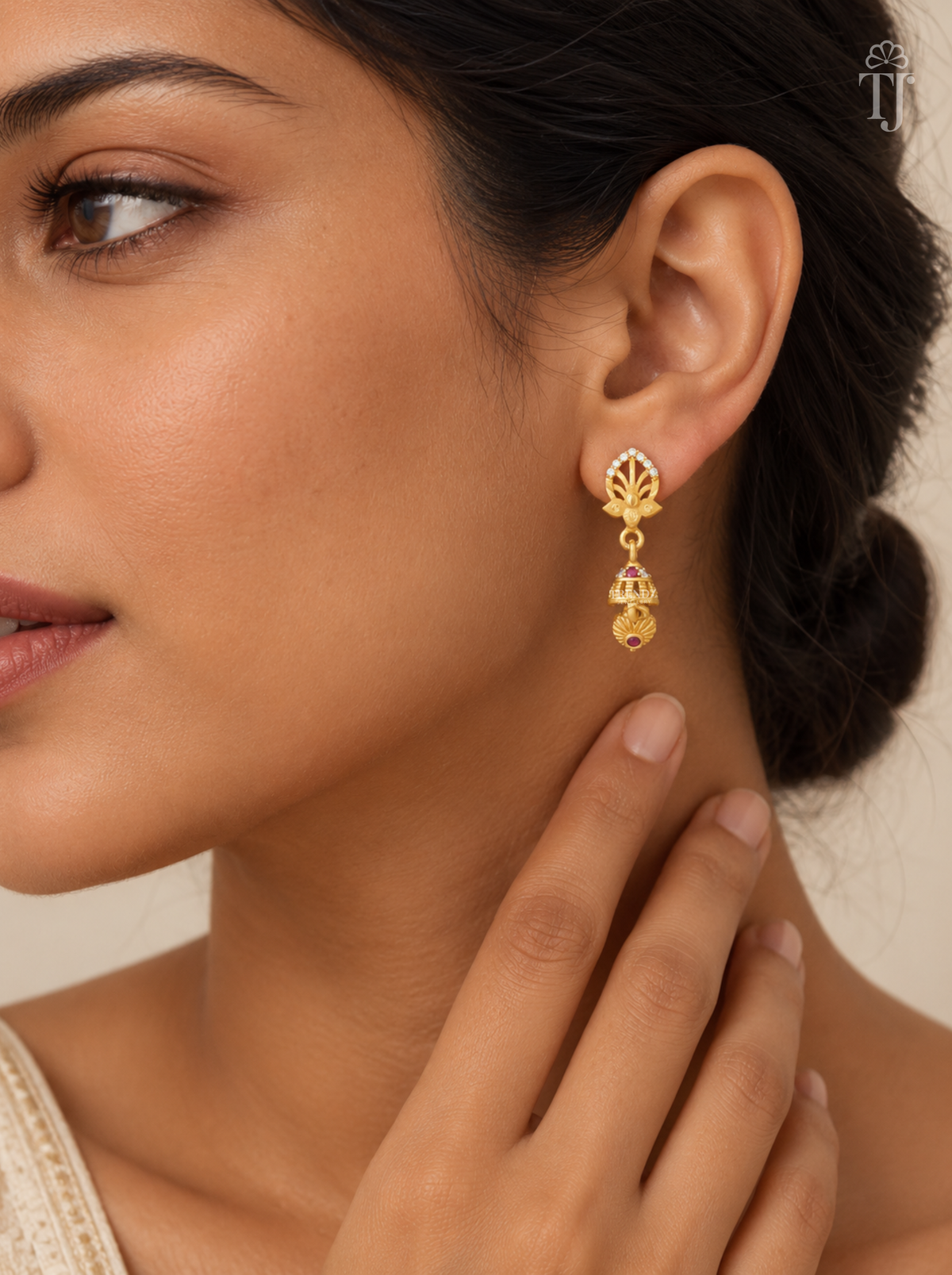 Woman wearing small gold plated lotus design jhumka earrings