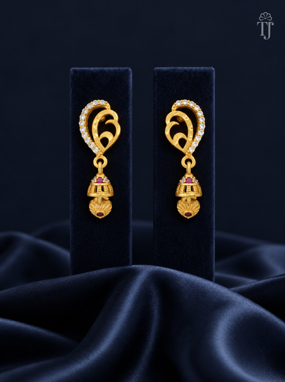 Gold plated mango design jhumka earrings with AD stones on navy display stand