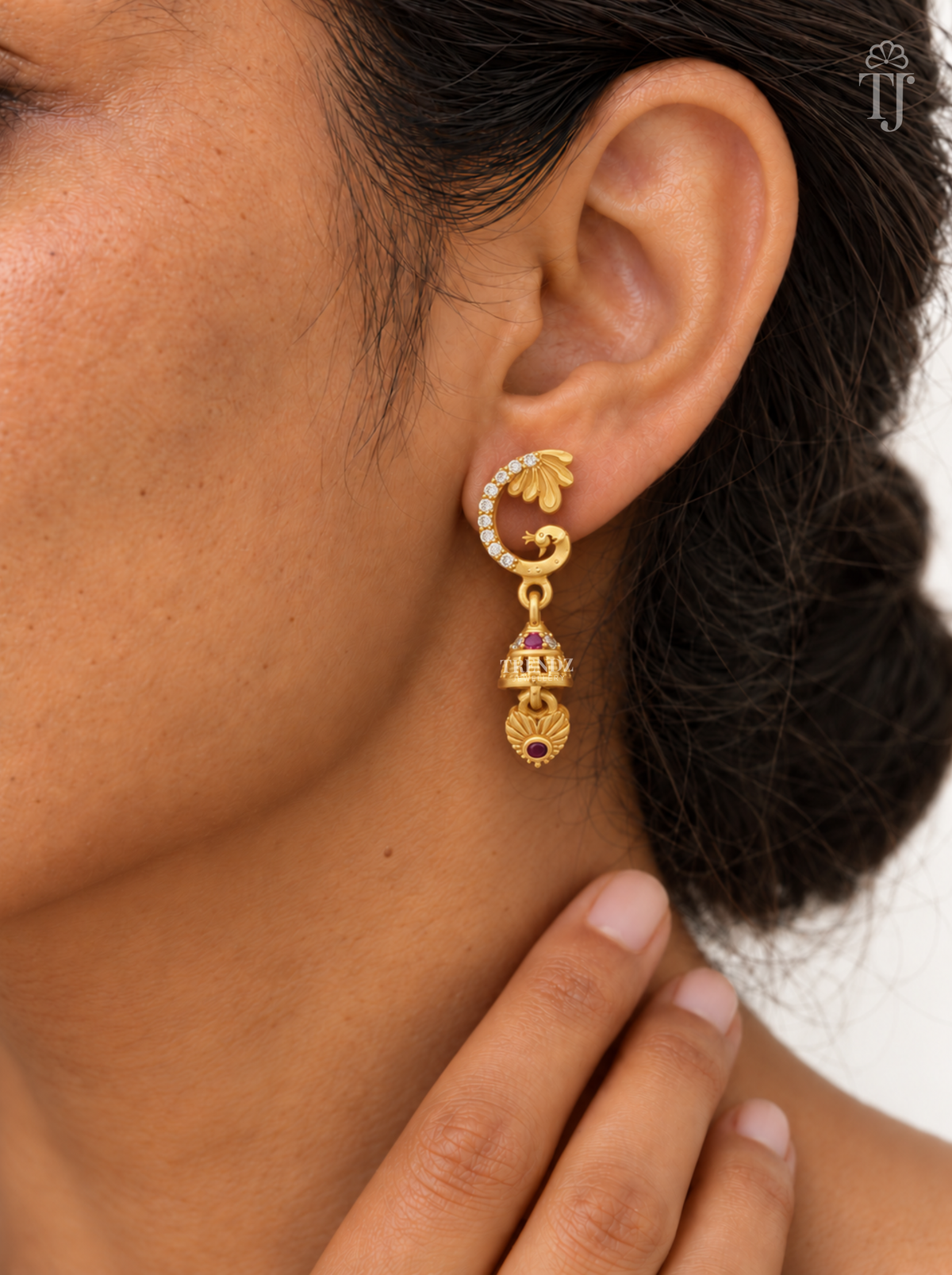 Woman wearing gold plated peacock design jhumka earrings