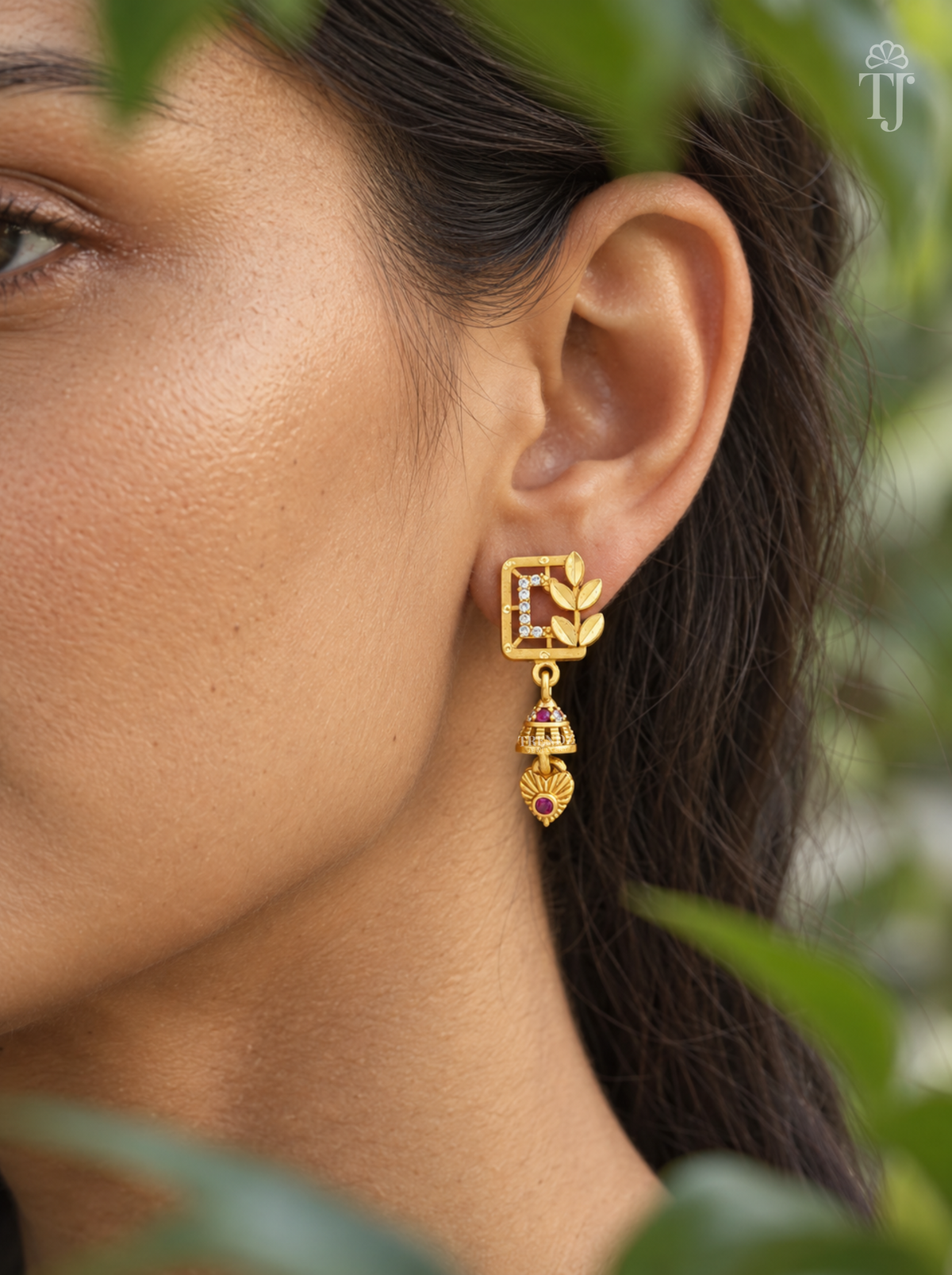Side view of woman wearing gold plated square jhumka drop earrings