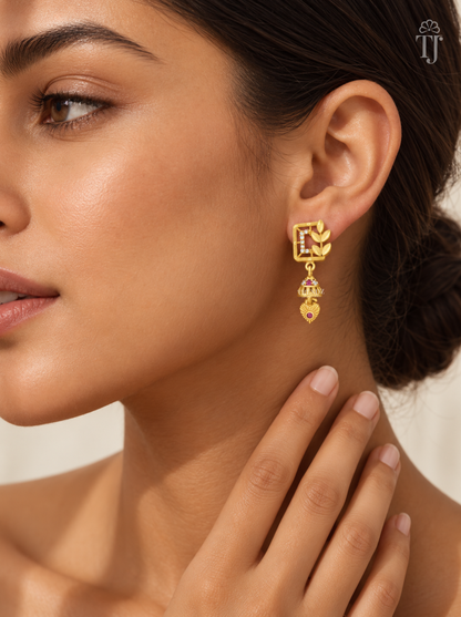 Woman wearing small gold plated square jhumka earrings with leaf branch