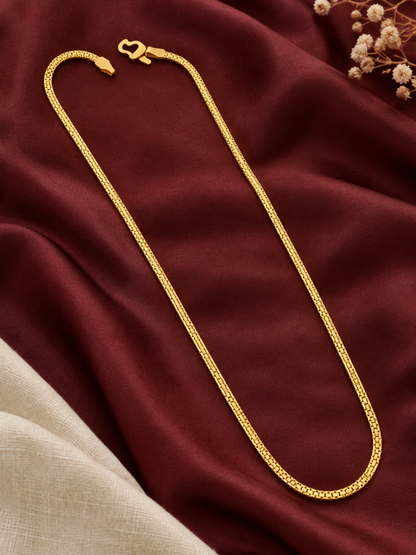 Thin gold plated box link chain laid on maroon fabric with linen and flowers