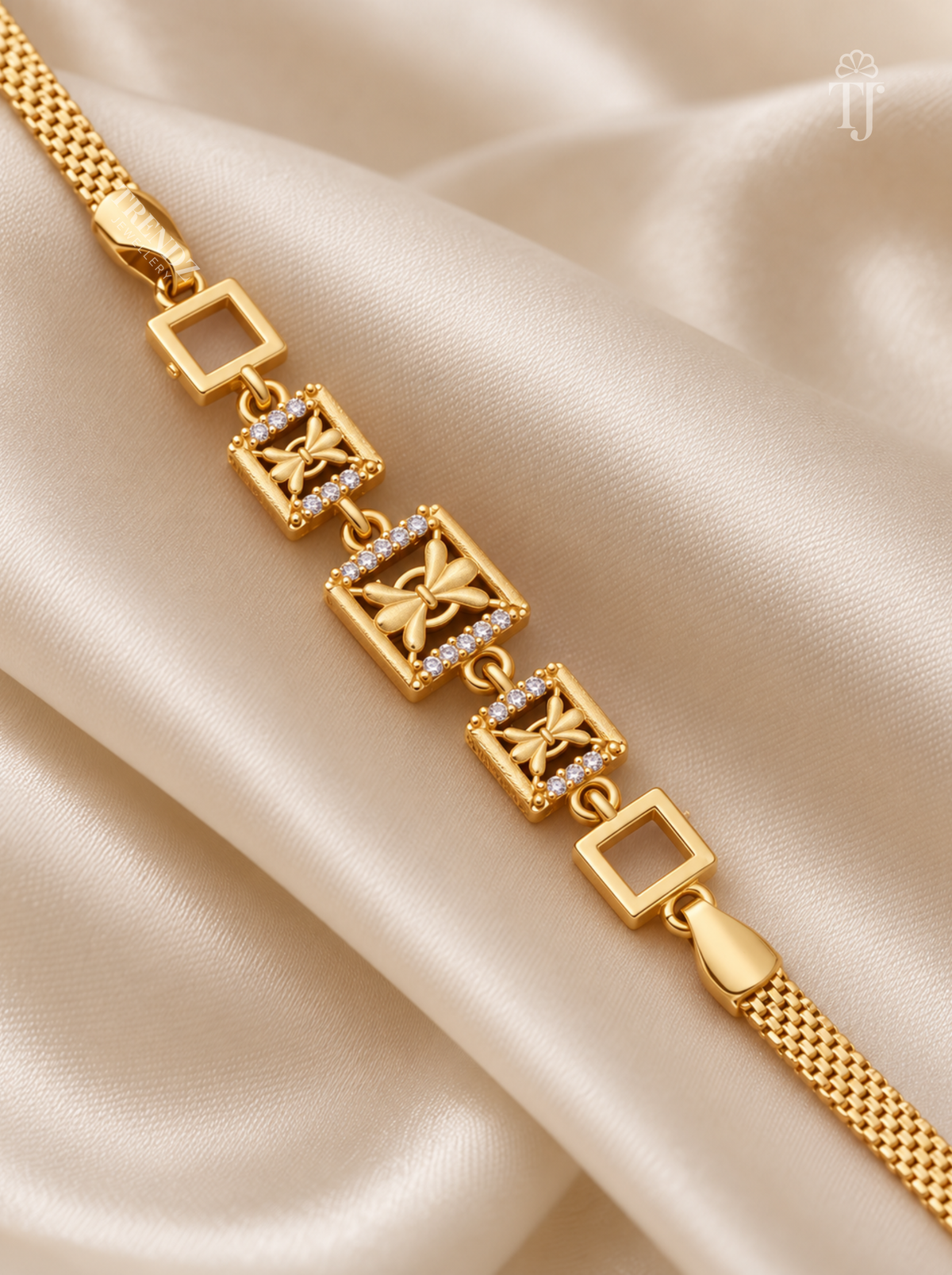 Close up of gold plated bracelet with butterfly motif and AD diamond square links