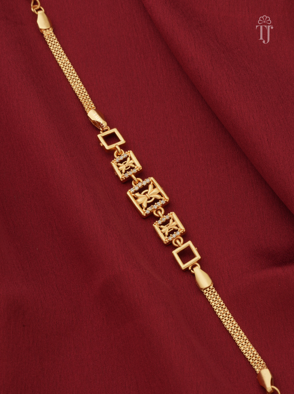 Designer gold plated AD diamond bracelet for women closeup on red cloth