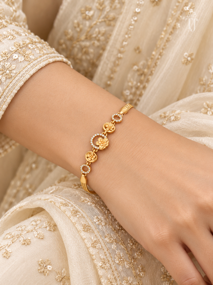 Woman wearing gold plated floral bracelet with white ethnic outfit
