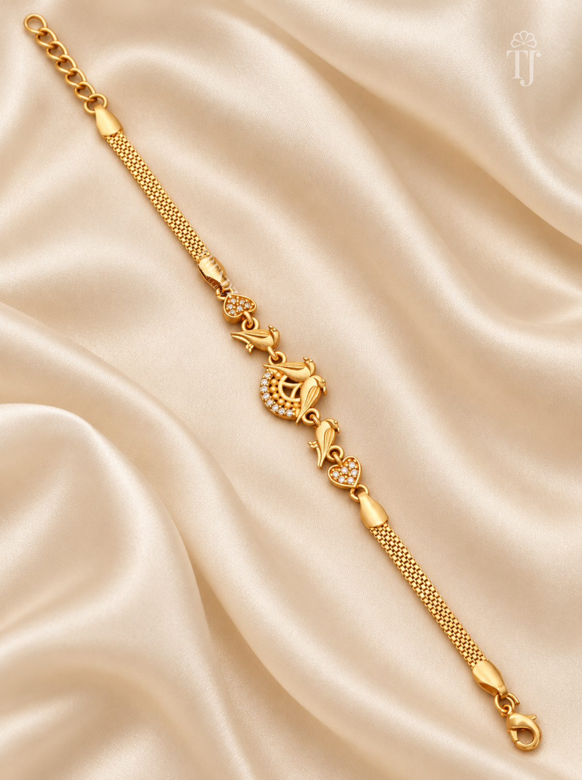 Gold plated parrot love bird designer bracelet flat lay on cream silk