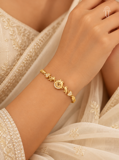 Woman wearing parrot gold plated bracelet with white saree