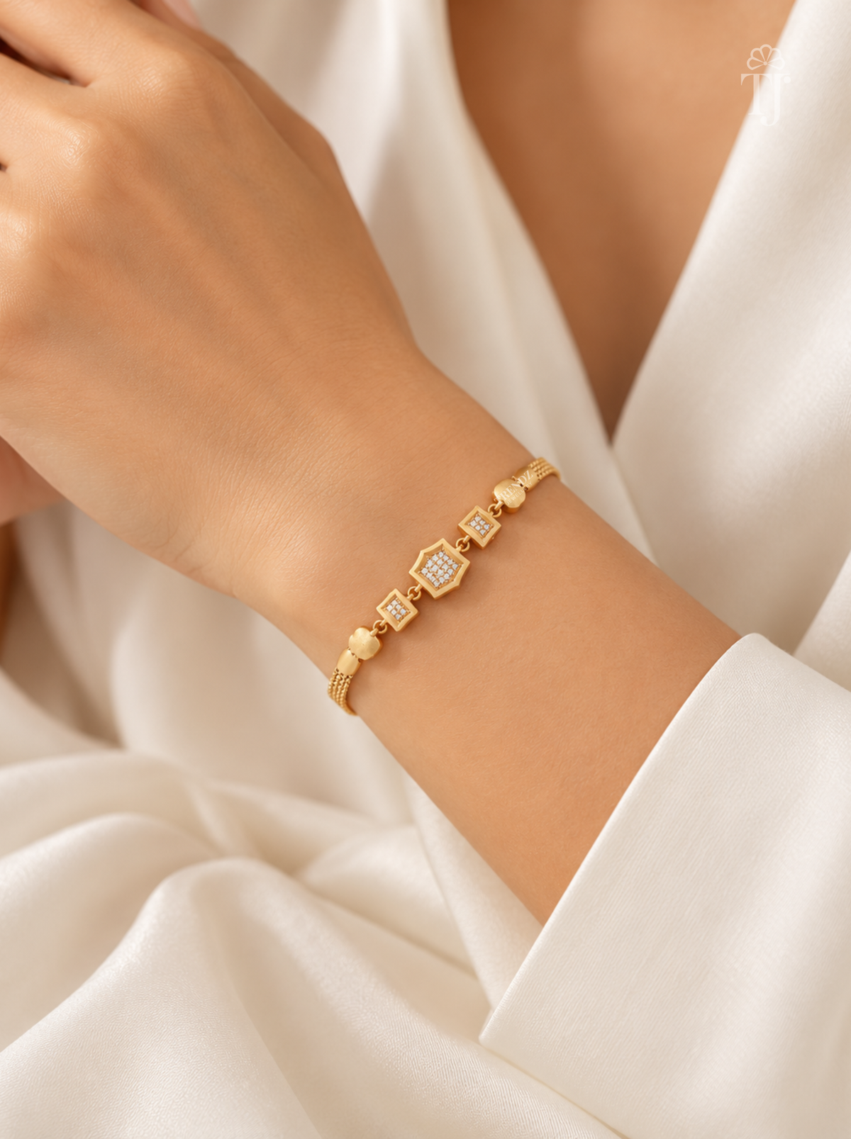 Woman wearing modern geometric gold plated bracelet with white saree