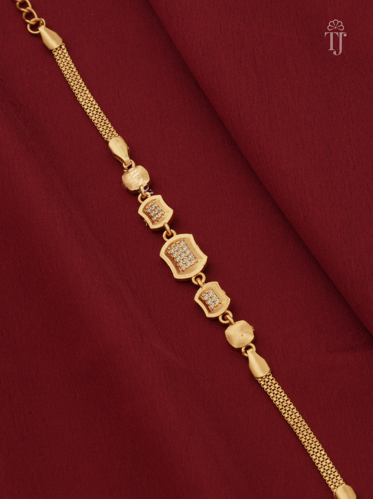 Gold plated rectangle cushion station bracelet with AD diamond on red cloth
