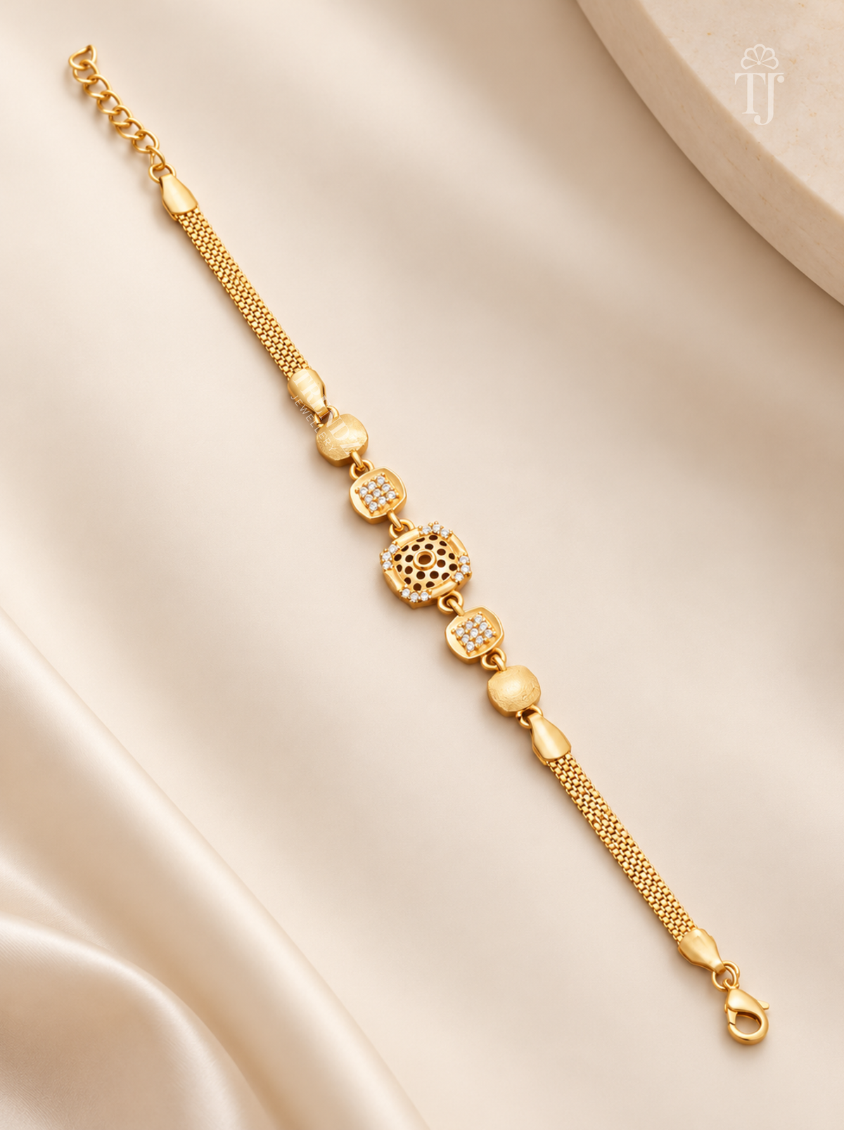 Premium gold plated square floral cutwork bracelet for women flat lay on cream silk