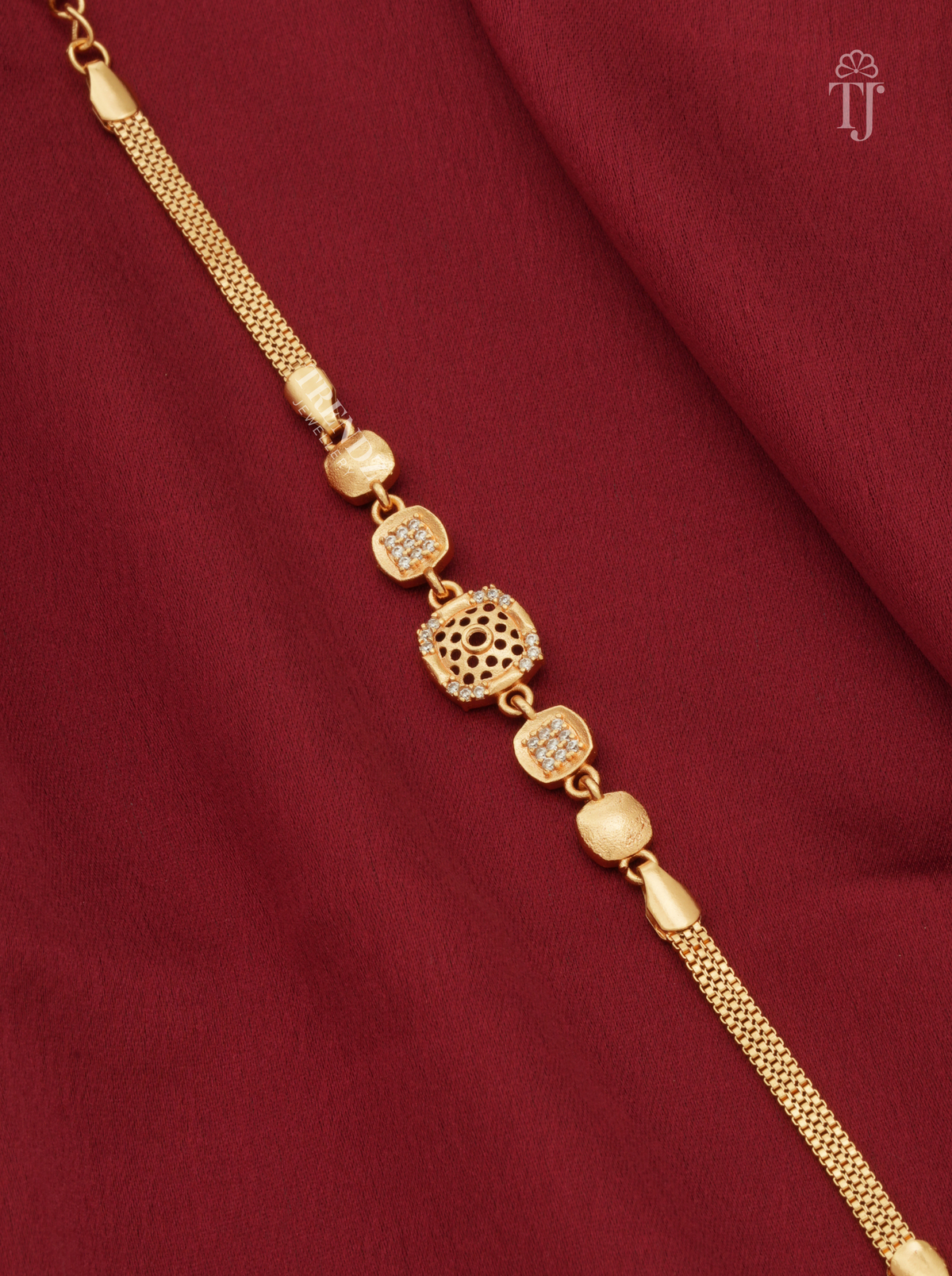 Premium gold plated square floral cutwork bracelet for girls on red fabric background